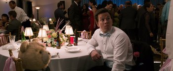A man sitting at a table with a bottle of wine