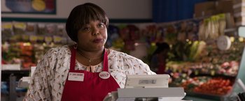 Movie still from “Ted 2” (2015), directed by Seth MacFarlane – A woman standing in front of a cash register in a store; Close Up shot, Over the shoulder angle