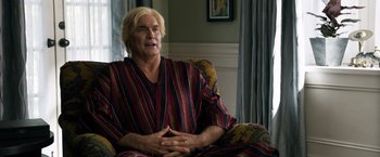 Movie still from “Ted 2” (2015), directed by Seth MacFarlane – An older man sitting on a chair in a room; Medium shot, Over the shoulder angle