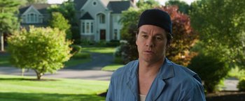 Movie still from “Ted 2” (2015), directed by Seth MacFarlane – A man wearing a hat standing in front of a house; Close Up shot, Over the shoulder angle