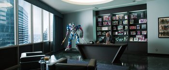 Movie still from “Ted 2” (2015), directed by Seth MacFarlane – A man sitting at a desk in front of a giant robot; Wide shot, Over the shoulder angle