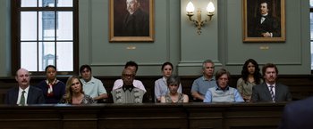 Movie still from “Ted 2” (2015), directed by Seth MacFarlane – A group of people sitting at a table in front of a painting; Wide shot, Low angle