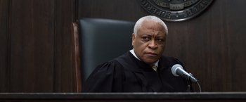 Movie still from “Ted 2” (2015), directed by Seth MacFarlane – A judge sitting in front of a microphone in a court room; Close Up shot, Low angle