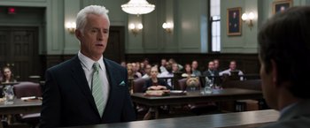 Movie still from “Ted 2” (2015), directed by Seth MacFarlane – A man standing in front of a group of people in a courtroom; Close Up shot, Over the shoulder angle