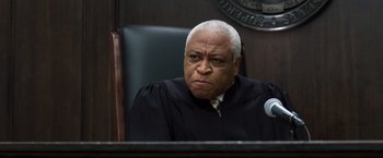 Movie still from “Ted 2” (2015), directed by Seth MacFarlane – An older man sitting in a judge's chair in a courtroom; Close Up shot, Low angle