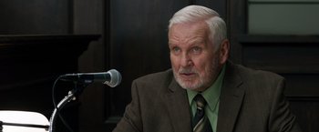 Movie still from “Ted 2” (2015), directed by Seth MacFarlane – An older man wearing a suit and a tie; Close Up shot, Over the shoulder angle