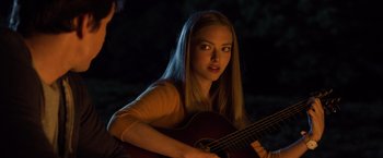 Movie still from “Ted 2” (2015), directed by Seth MacFarlane – A woman holding a guitar while sitting in the dark; Close Up shot, Over the shoulder angle