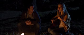 Movie still from “Ted 2” (2015), directed by Seth MacFarlane – A man and a woman sitting on the ground in the dark; Medium shot, Over the shoulder angle