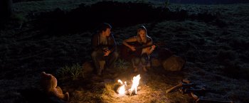 Movie still from “Ted 2” (2015), directed by Seth MacFarlane – A man and a woman sitting in front of a fire; Wide shot, Over the shoulder angle