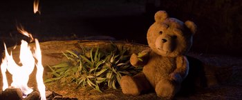 Movie still from “Ted 2” (2015), directed by Seth MacFarlane – A brown teddy bear sitting next to a plant; Medium shot, Low angle
