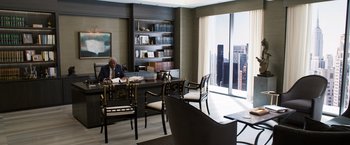 Movie still from “Ted 2” (2015), directed by Seth MacFarlane – A man sitting at a desk in a room with a view of a skyscraper; Wide shot, High angle