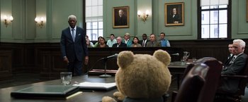 Movie still from “Ted 2” (2015), directed by Seth MacFarlane – A teddy bear sitting in the middle of a court room; Wide shot, Over the shoulder angle