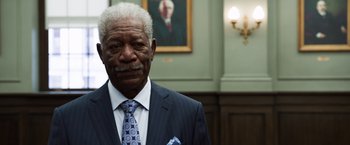 Movie still from “Ted 2” (2015), directed by Seth MacFarlane – An older man wearing a suit and tie in front of a painting; Close Up shot, Low angle