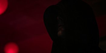Movie still from “Teen Wolf: The Movie” (2023), directed by Russell Mulcahy – A man in a black hooded jacket is in the dark; Extreme Close Up shot, Low angle