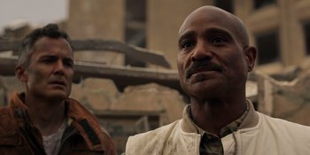 Movie still from “Teen Wolf: The Movie” (2023), directed by Russell Mulcahy – A man with a beard is standing in front of a building; Close Up shot, Over the shoulder angle