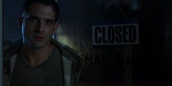 Movie still from “Teen Wolf: The Movie” (2023), directed by Russell Mulcahy – A man standing in front of a closed sign; Close Up shot, Over the shoulder angle