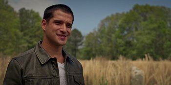 Movie still from “Teen Wolf: The Movie” (2023), directed by Russell Mulcahy – A young man standing in front of a field of tall grass; Close Up shot, Over the shoulder angle