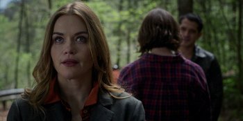 Movie still from “Teen Wolf: The Movie” (2023), directed by Russell Mulcahy – A woman in a plaid shirt is looking at the camera while a man in a plaid shirt looks on; Close Up shot, Over the shoulder angle