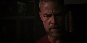 Movie still from “Teen Wolf: The Movie” (2023), directed by Russell Mulcahy – A person with a beard looking at the camera; Close Up shot, Over the shoulder angle