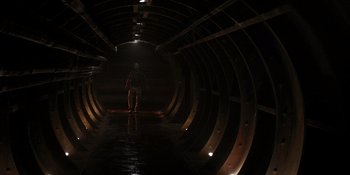 Movie still from “Teen Wolf: The Movie” (2023), directed by Russell Mulcahy – A man riding a skateboard down the side of a tunnel; Wide shot, Low angle