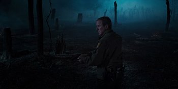Movie still from “Teen Wolf: The Movie” (2023), directed by Russell Mulcahy – A man in a field with trees in the background at night; Medium shot, Over the shoulder angle