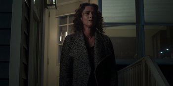 Movie still from “Teen Wolf: The Movie” (2023), directed by Russell Mulcahy – A woman with curly hair standing in a dark room; Medium shot, Low angle