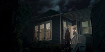 Movie still from “Teen Wolf: The Movie” (2023), directed by Russell Mulcahy – Two people standing in front of a house at night; Extreme Wide shot, Low angle