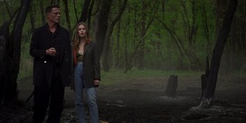 Movie still from “Teen Wolf: The Movie” (2023), directed by Russell Mulcahy – A woman standing next to a man in the woods; Wide shot, Low angle