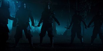Movie still from “Teen Wolf: The Movie” (2023), directed by Russell Mulcahy – A group of people standing next to each other in the dark; Wide shot, Low angle