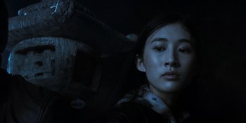 Movie still from “Teen Wolf: The Movie” (2023), directed by Russell Mulcahy – A young asian woman in the dark looking at the camera; Close Up shot, Low angle