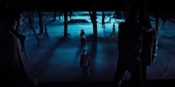 Movie still from “Teen Wolf: The Movie” (2023), directed by Russell Mulcahy – A man and a woman are standing in the dark; Extreme Wide shot, High angle