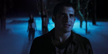 Movie still from “Teen Wolf: The Movie” (2023), directed by Russell Mulcahy – A man in a dark room looking at the camera; Close Up shot, Over the shoulder angle