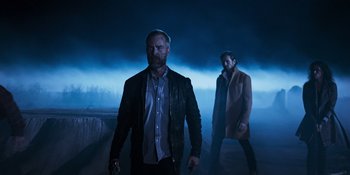 Movie still from “Teen Wolf: The Movie” (2023), directed by Russell Mulcahy – Two men are standing in the dark in the fog; Medium shot, Low angle
