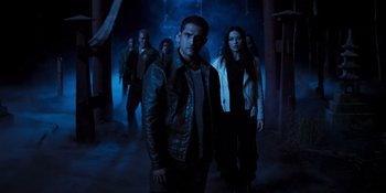 Movie still from “Teen Wolf: The Movie” (2023), directed by Russell Mulcahy – A group of people standing in a dark room; Medium shot, Low angle