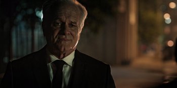 Movie still from “Teen Wolf: The Movie” (2023), directed by Russell Mulcahy – An older man wearing a suit and tie; Close Up shot, Over the shoulder angle