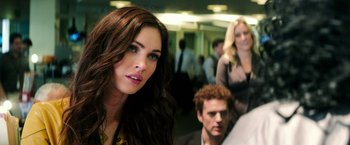 Movie still from “Teenage Mutant Ninja Turtles” (2014), directed by Jonathan Liebesman – A beautiful young woman standing next to a man; Close Up shot, Over the shoulder angle