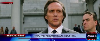 Movie still from “Teenage Mutant Ninja Turtles” (2014), directed by Jonathan Liebesman – A man in a suit and tie on a news set; Close Up shot, Over the shoulder angle