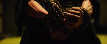Movie still from “Teenage Mutant Ninja Turtles” (2014), directed by Jonathan Liebesman – A person holding a rope in their hands; Extreme Close Up shot, High angle