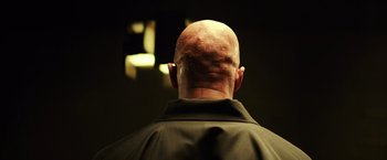 Movie still from “Teenage Mutant Ninja Turtles” (2014), directed by Jonathan Liebesman – A man with a shaved head and a black shirt; Close Up shot, Low angle
