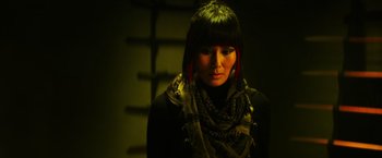 Movie still from “Teenage Mutant Ninja Turtles” (2014), directed by Jonathan Liebesman – A woman wearing a black shirt and a black scarf; Close Up shot, Over the shoulder angle