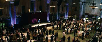 Movie still from “Teenage Mutant Ninja Turtles” (2014), directed by Jonathan Liebesman – A crowd of people sitting at tables in front of a man on a stage; Extreme Wide shot, High angle