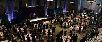Movie still from “Teenage Mutant Ninja Turtles” (2014), directed by Jonathan Liebesman – A large group of people sitting at tables in front of a stage; Extreme Wide shot, High angle