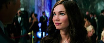 Movie still from “Teenage Mutant Ninja Turtles” (2014), directed by Jonathan Liebesman – A woman with long brown hair and green eyes looking to her left; Close Up shot, Over the shoulder angle