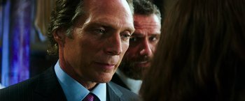 Movie still from “Teenage Mutant Ninja Turtles” (2014), directed by Jonathan Liebesman – A man in a suit and tie next to another man in a suit and tie; Close Up shot, Over the shoulder angle