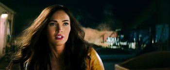 Movie still from “Teenage Mutant Ninja Turtles” (2014), directed by Jonathan Liebesman – A person wearing a yellow jacket; Close Up shot, Over the shoulder angle