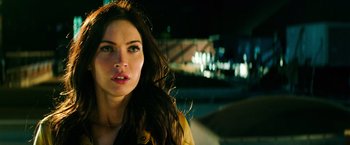 Movie still from “Teenage Mutant Ninja Turtles” (2014), directed by Jonathan Liebesman – A beautiful young lady standing next to a street; Close Up shot, Low angle