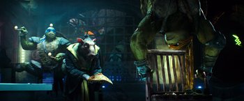 Movie still from “Teenage Mutant Ninja Turtles” (2014), directed by Jonathan Liebesman – A man and a woman dressed up in costume; Medium shot, Over the shoulder angle