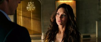 Movie still from “Teenage Mutant Ninja Turtles” (2014), directed by Jonathan Liebesman – A beautiful young woman with long brown hair and blue eyes; Close Up shot, Over the shoulder angle