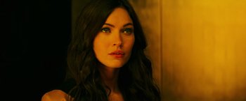 Movie still from “Teenage Mutant Ninja Turtles” (2014), directed by Jonathan Liebesman – A beautiful woman with long black hair and green eyes looking at the camera; Close Up shot, Over the shoulder angle