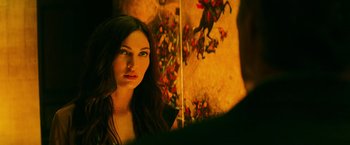 Movie still from “Teenage Mutant Ninja Turtles” (2014), directed by Jonathan Liebesman – A beautiful young woman standing in front of a painting; Close Up shot, Over the shoulder angle